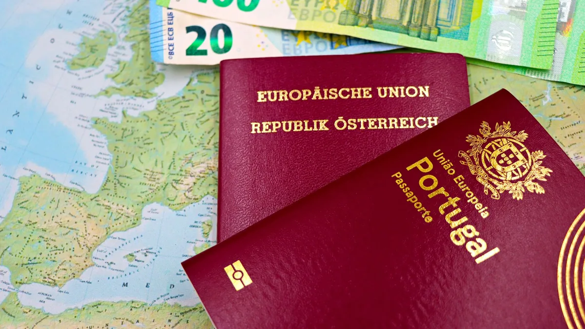 Austrian and Portuguese passports on a European map with euro banknotes.