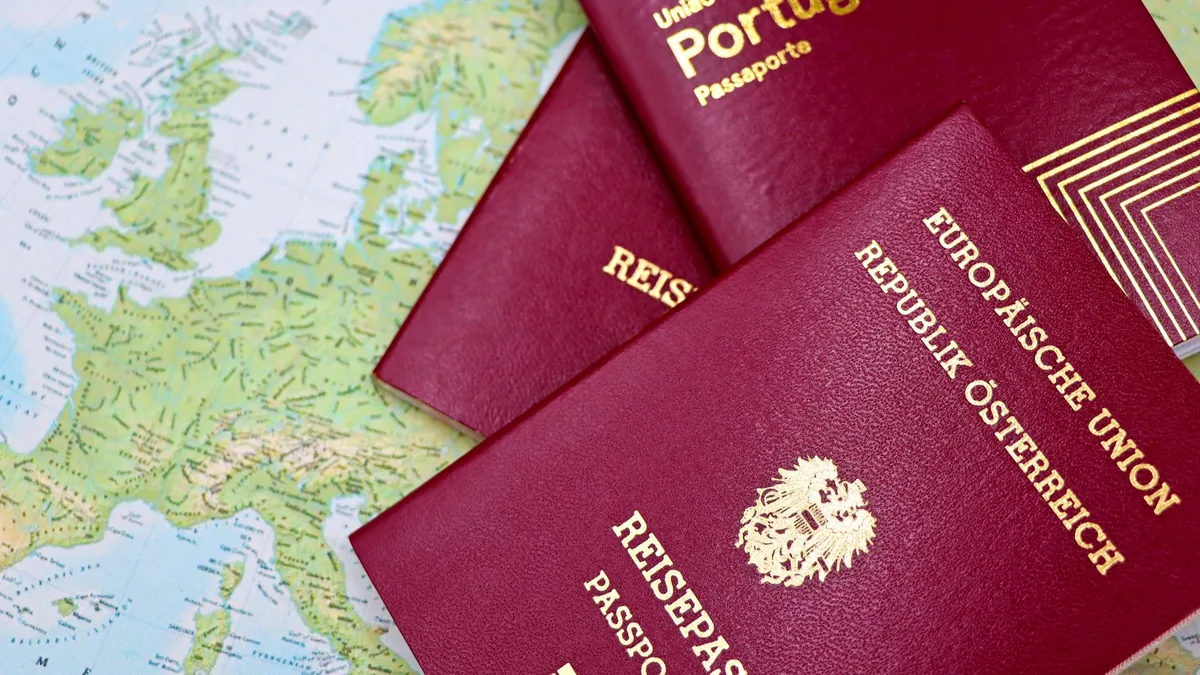 Close-up of European passports from Portugal and Austria on a world map.