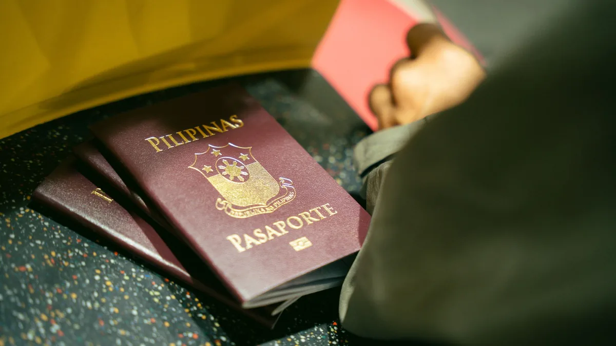 A close-up shot of Filipino passports at the airport, indicating travel and identity.